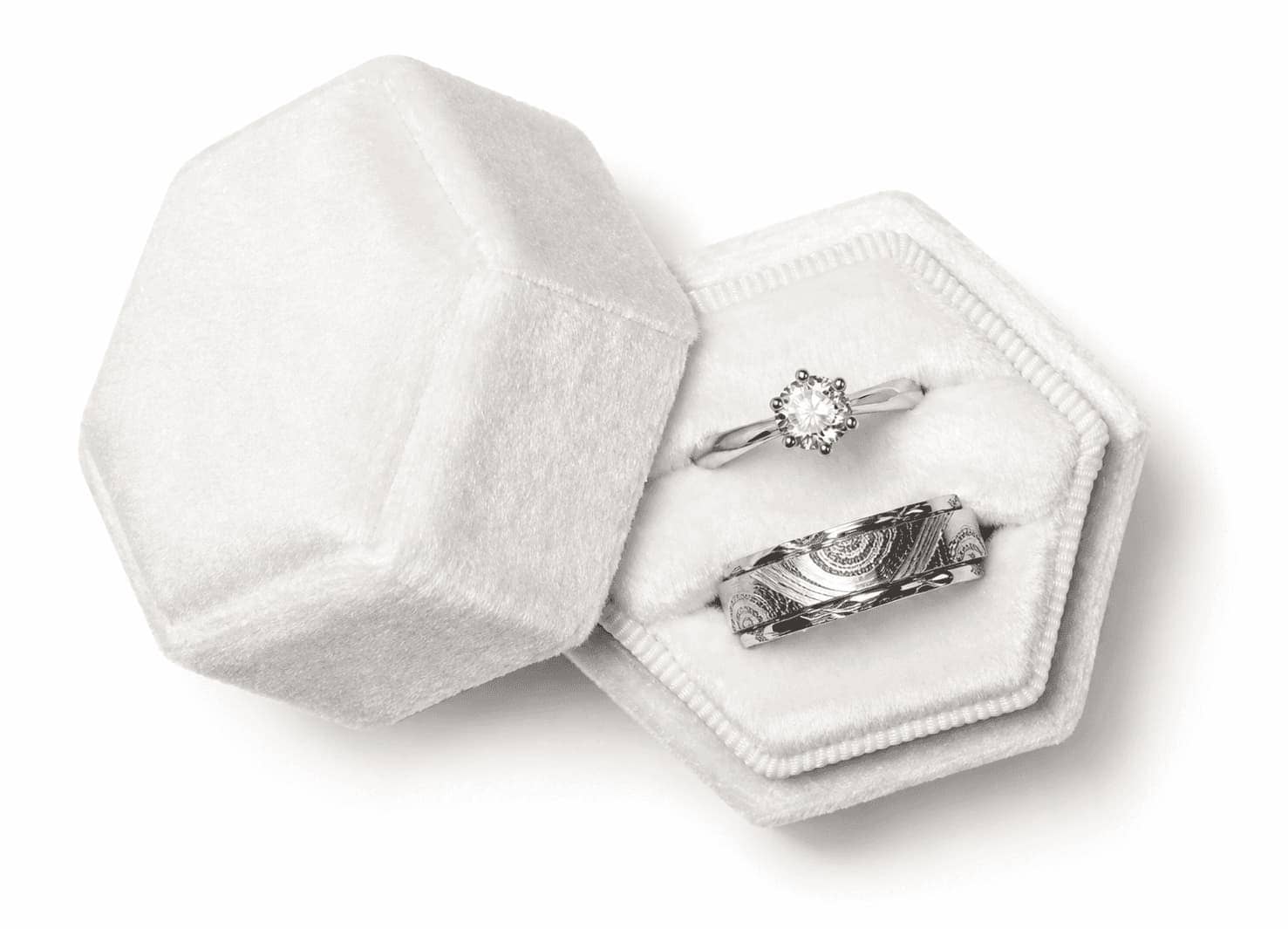 Diamond engagement ring and patterned wedding band in a hexagonal jewellery box