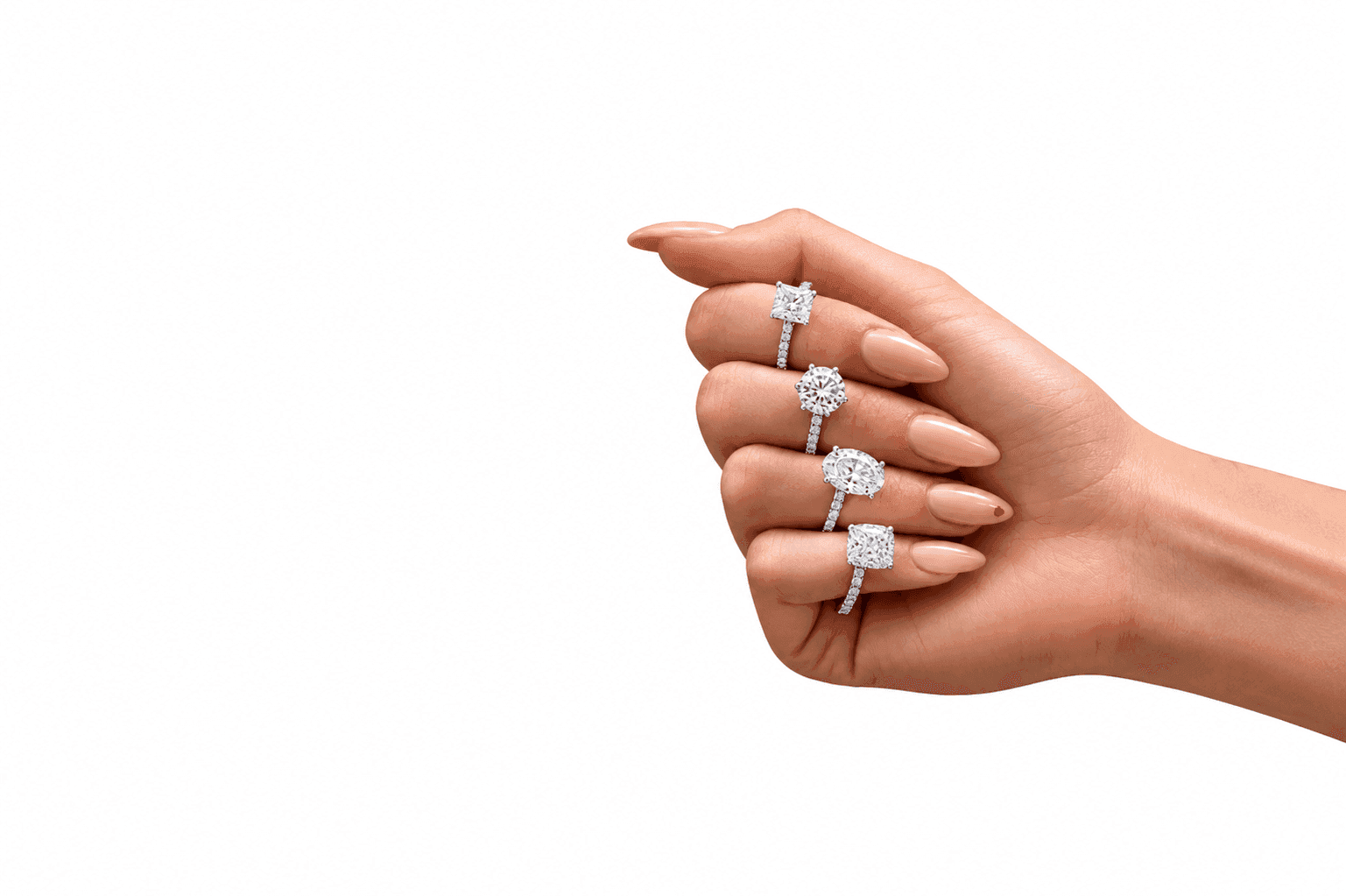 Hand wearing four diamond engagement rings in different cuts